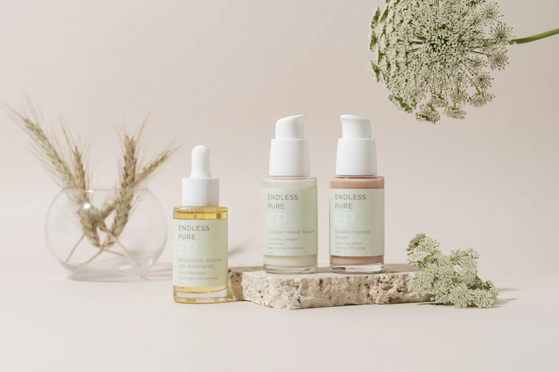 Neutral skincare bottles styled with dried florals
